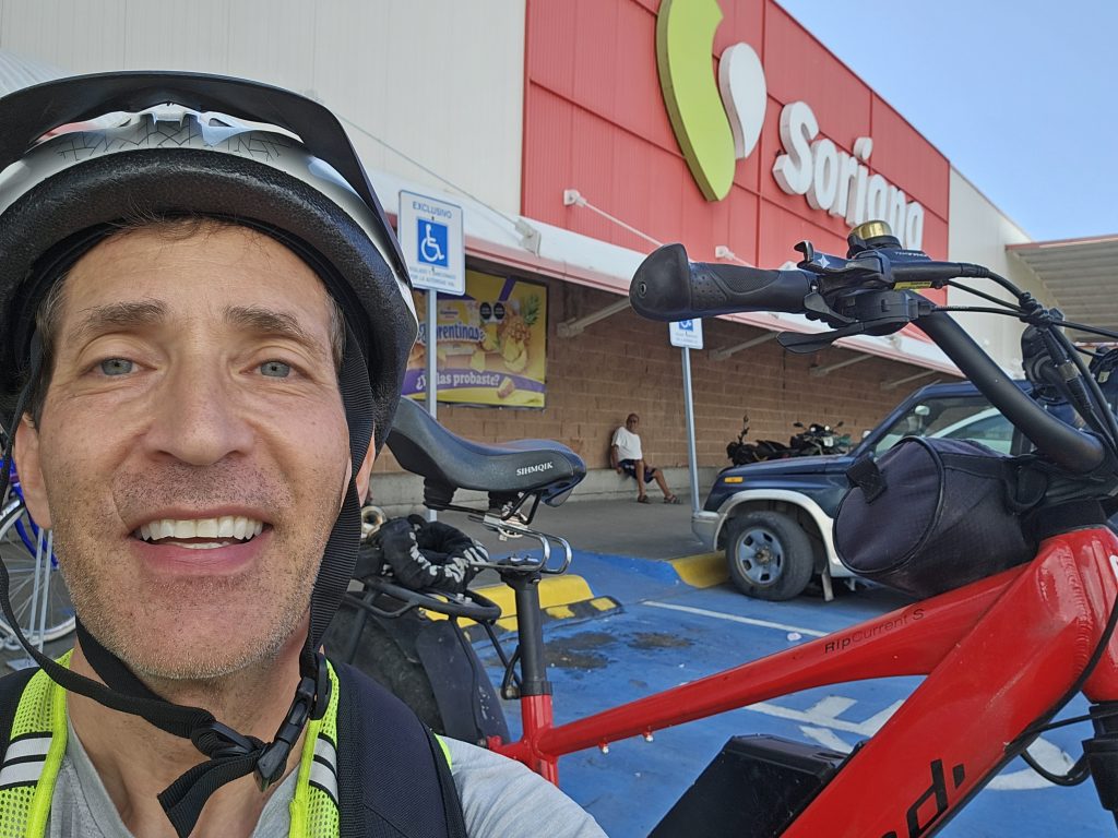 Man next to bike in front of grocery store Soriana in Chapala, Mexico